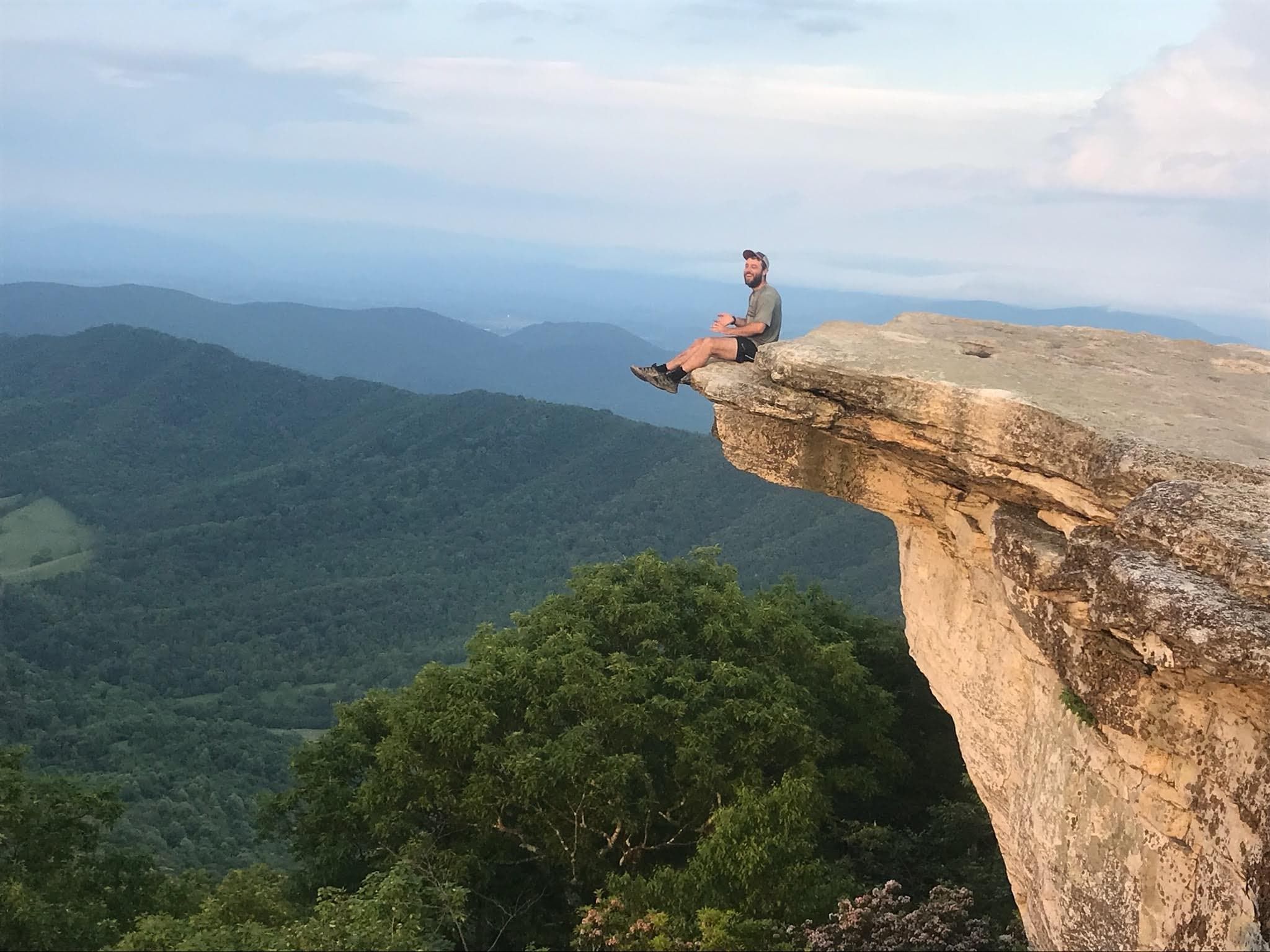 Trailblaze Digital founder Ruairi seated on a mountain cliff